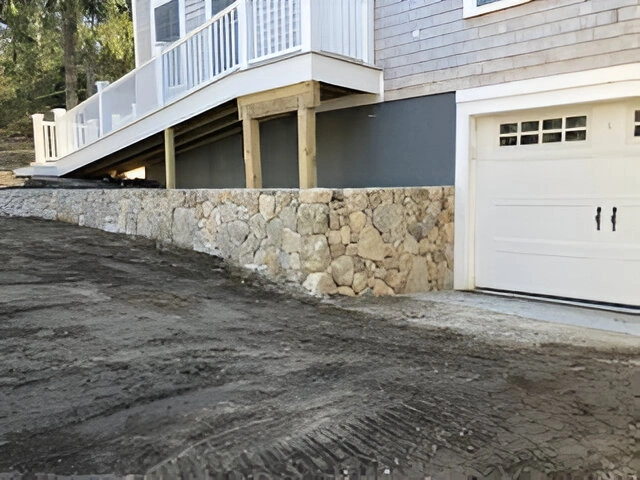 Stone retaining wall from a house in Falmouth, MA. Designed by Cape Cod Hardscapes